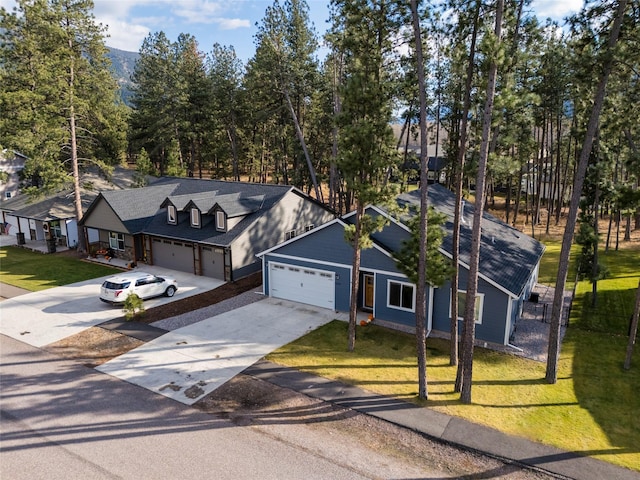 view of front of property featuring a front lawn, concrete driveway, and a garage