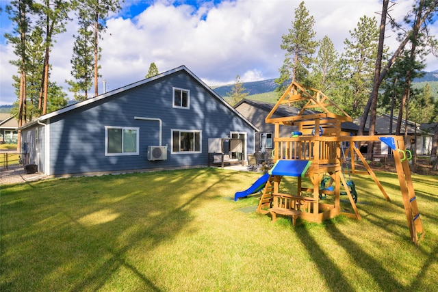 rear view of property featuring a lawn and a playground