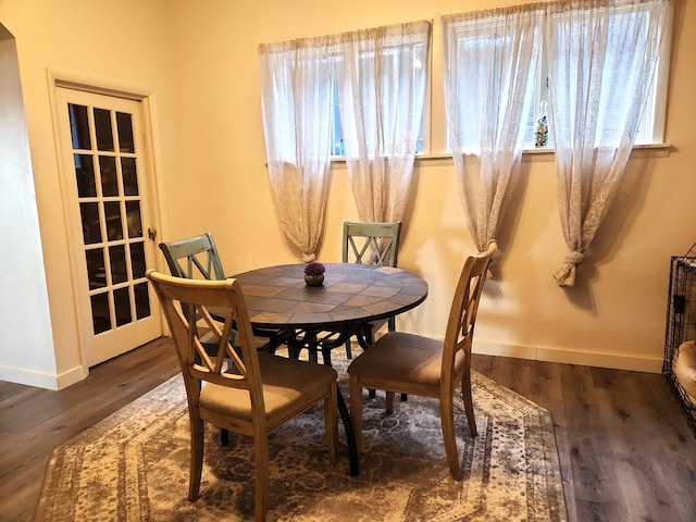 dining space featuring baseboards and wood finished floors