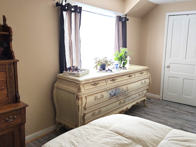 bedroom with baseboards and wood finished floors