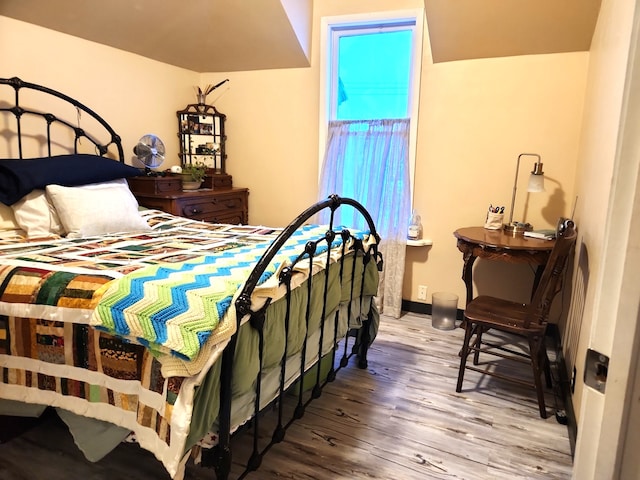 bedroom featuring baseboards and wood finished floors