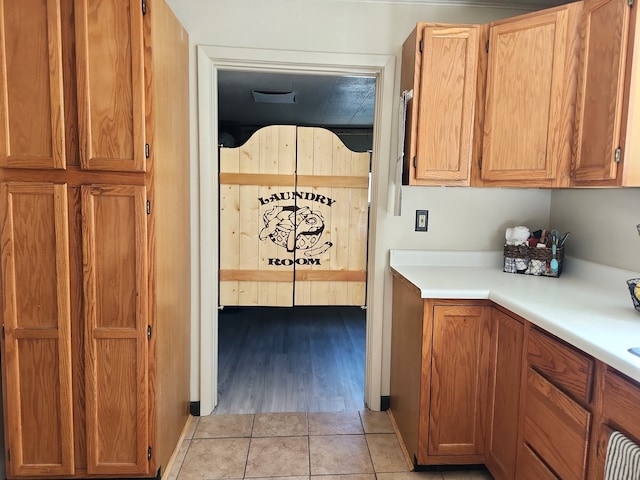 kitchen with light tile patterned flooring, brown cabinets, and light countertops