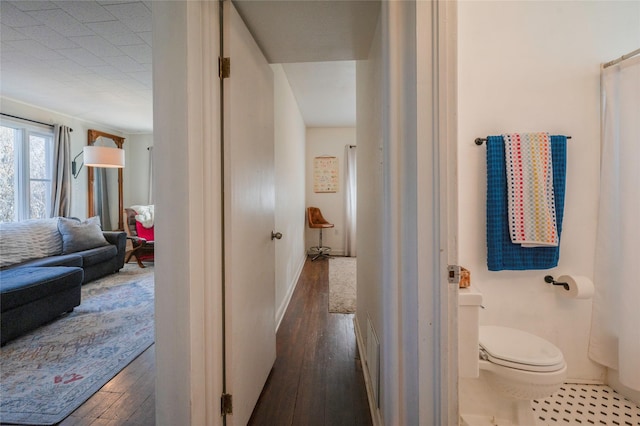 hallway featuring hardwood / wood-style flooring and baseboards