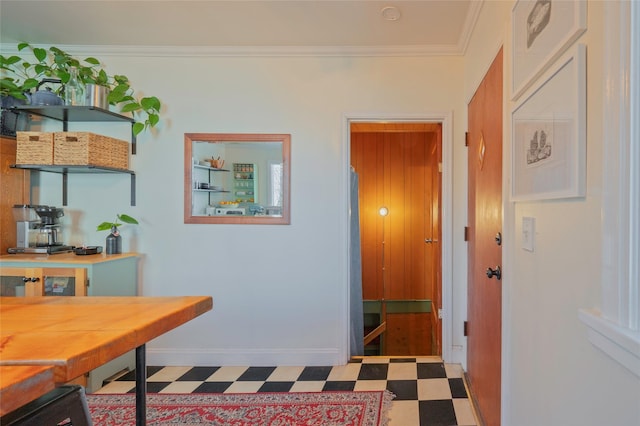 hall featuring tile patterned floors, baseboards, and ornamental molding