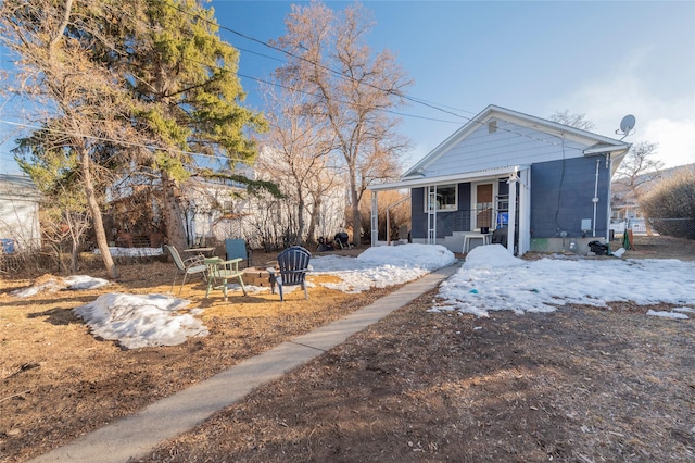 view of front of home with fence, covered porch, and an outdoor fire pit