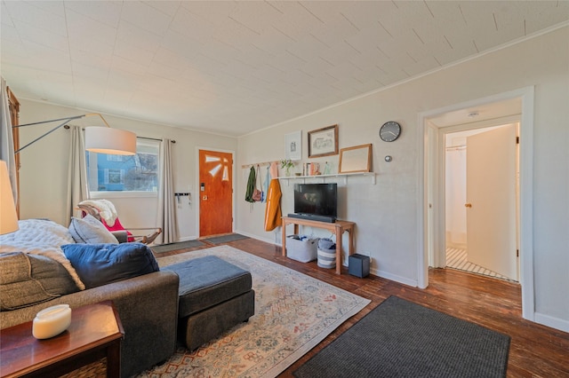 living room with crown molding, wood finished floors, and baseboards