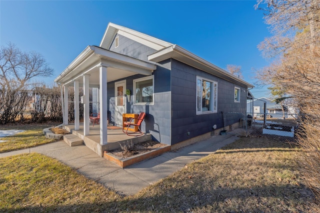 view of home's exterior featuring a yard, a porch, and fence