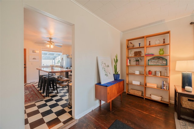 interior space featuring built in shelves, crown molding, baseboards, tile patterned floors, and a ceiling fan