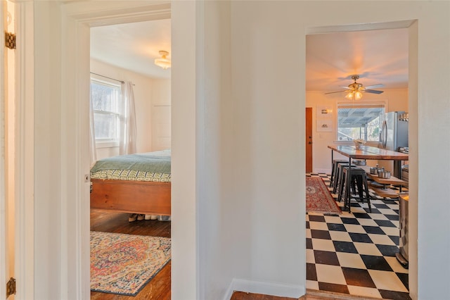 corridor featuring tile patterned floors and baseboards