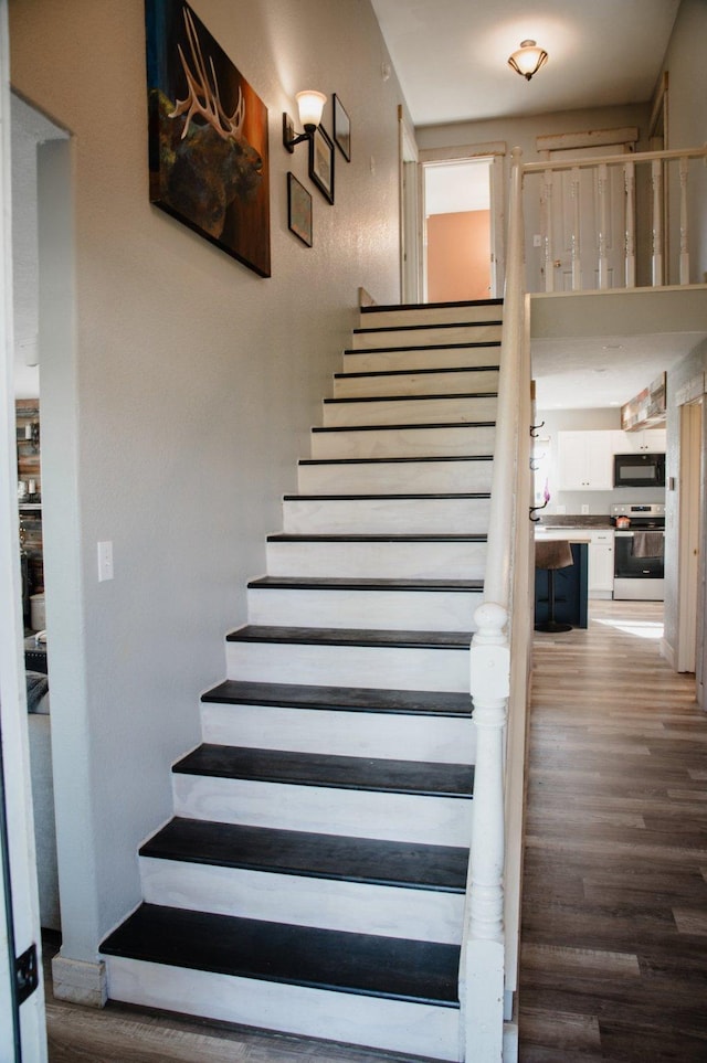 stairway featuring wood finished floors