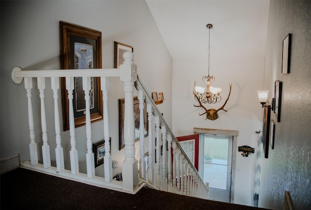 stairway featuring a notable chandelier and a towering ceiling