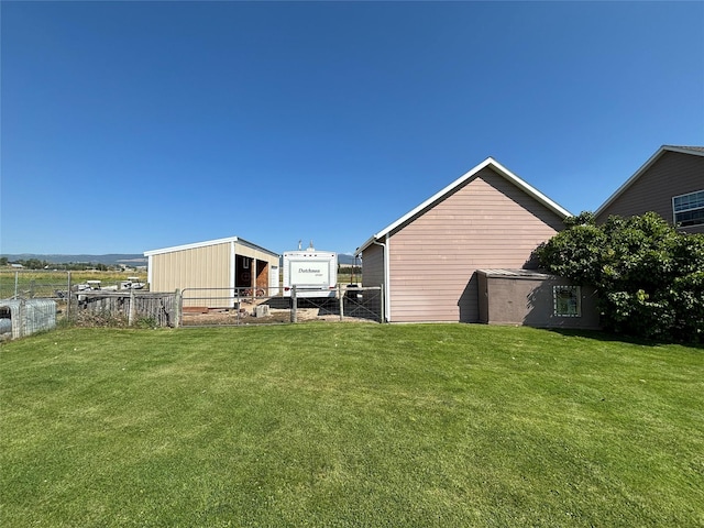 view of yard featuring an outbuilding and fence