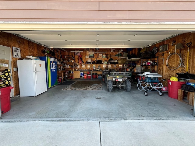 garage featuring a workshop area and freestanding refrigerator