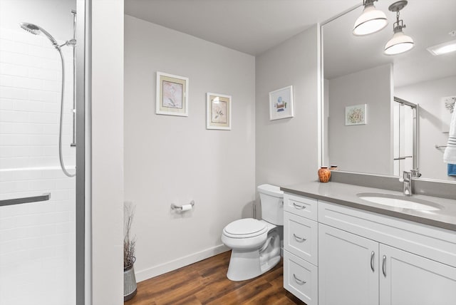 full bathroom with vanity, wood finished floors, baseboards, walk in shower, and toilet