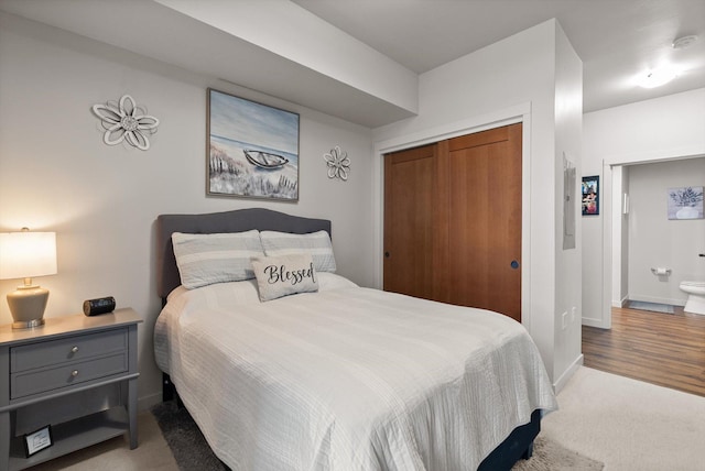 carpeted bedroom with a closet and baseboards