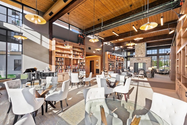 dining area featuring beam ceiling, wooden ceiling, and a towering ceiling