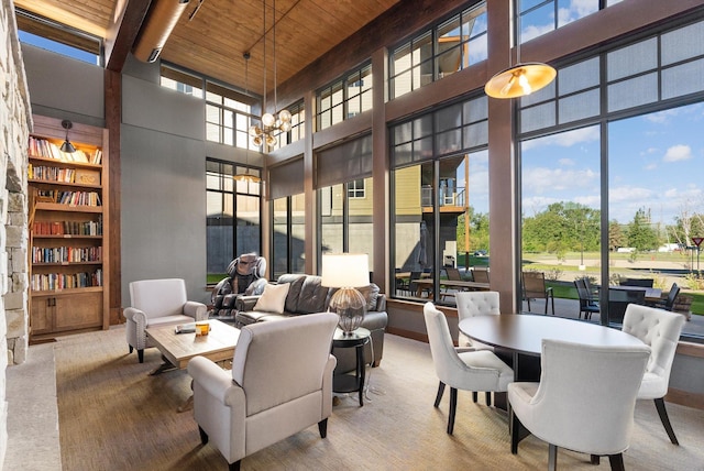 interior space featuring a high ceiling, a notable chandelier, wood ceiling, and carpet flooring