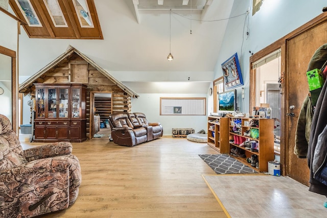 living room with wood finished floors and high vaulted ceiling