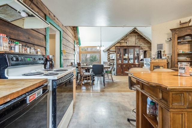 interior space featuring butcher block countertops, electric stove, open shelves, black dishwasher, and lofted ceiling