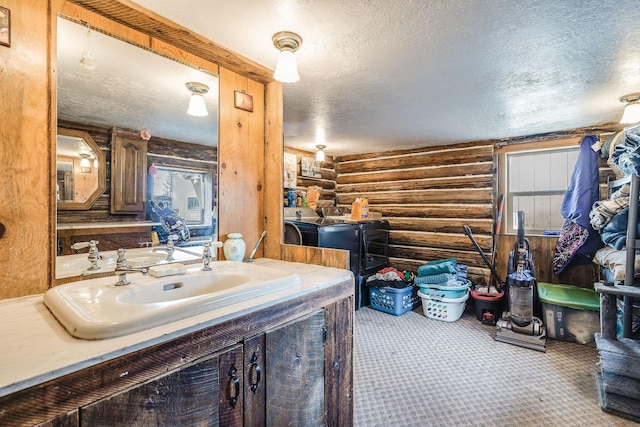 bathroom featuring vanity, log walls, and a textured ceiling