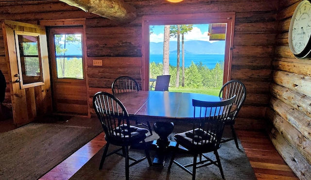 dining area with rustic walls and hardwood / wood-style floors