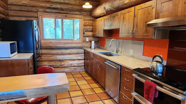 kitchen featuring backsplash, light countertops, brown cabinets, stainless steel appliances, and a sink