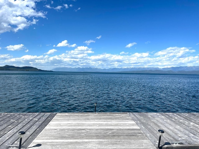 view of dock with a water and mountain view