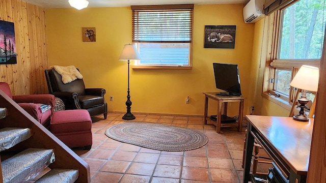 living area with a wall mounted air conditioner and baseboards