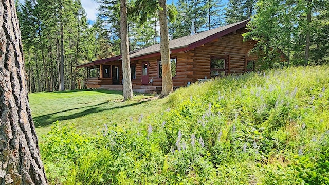 view of property exterior with a lawn and log exterior