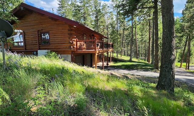 view of side of property with log siding and a wooden deck