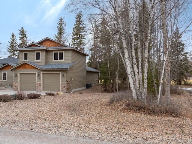 view of front of home with roof with shingles, an attached garage, concrete driveway, stone siding, and central air condition unit