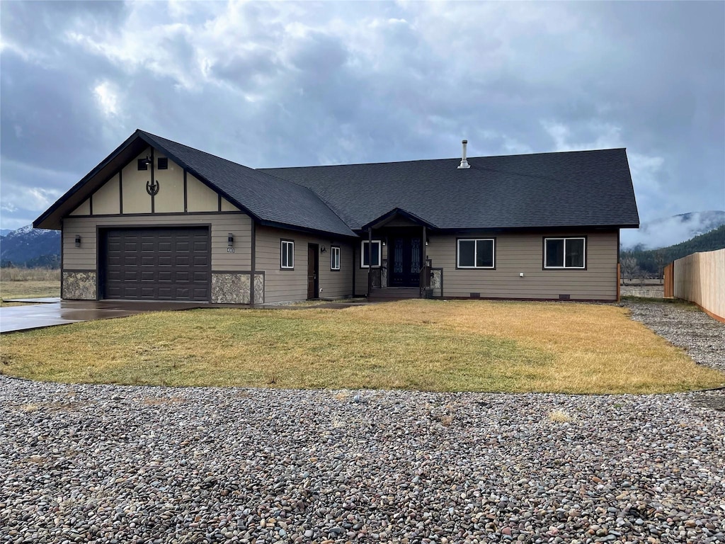 view of front of house with driveway, fence, roof with shingles, a front yard, and an attached garage