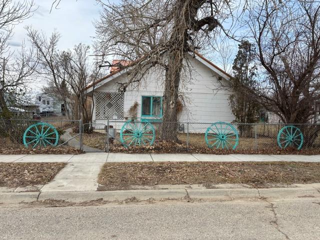 view of side of home with a fenced front yard and a gate