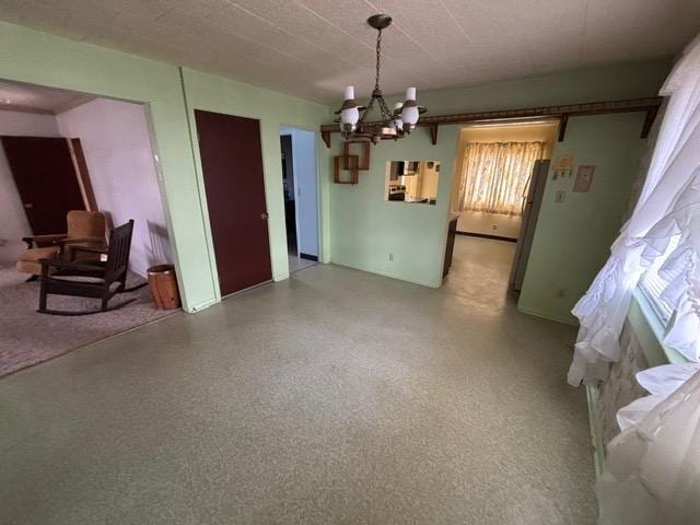 dining area with speckled floor and a notable chandelier