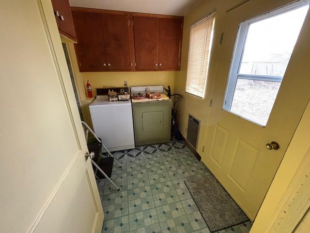 laundry room with cabinet space and light floors