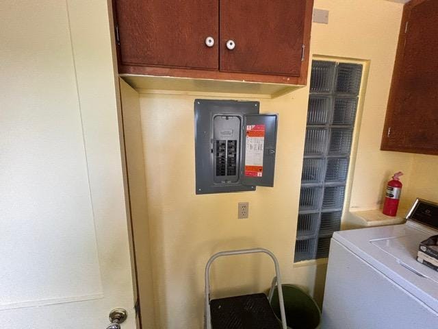 laundry room featuring cabinet space, washer / dryer, and electric panel