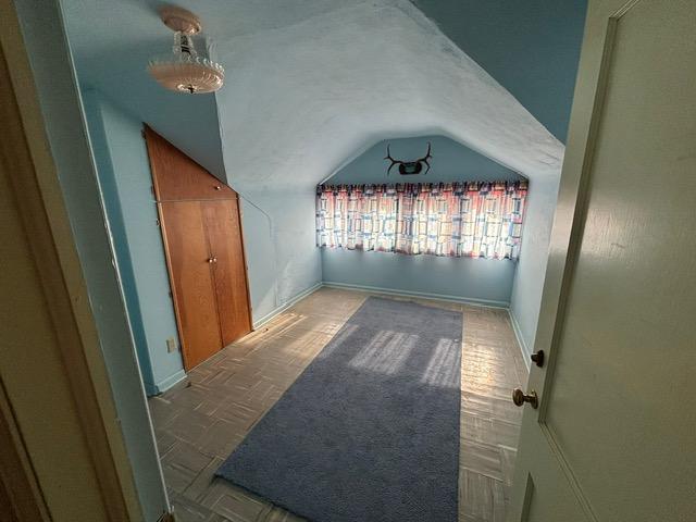 bonus room featuring baseboards and vaulted ceiling