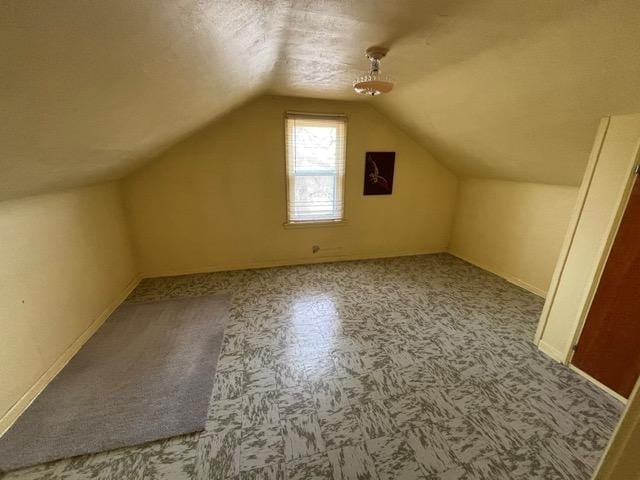 bonus room with vaulted ceiling and a textured ceiling