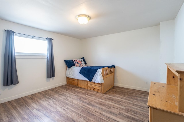 bedroom featuring wood finished floors and baseboards