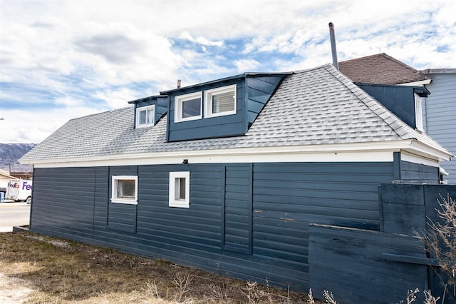 view of side of home featuring roof with shingles