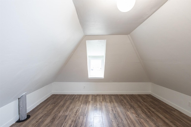 additional living space featuring baseboards, wood finished floors, and vaulted ceiling