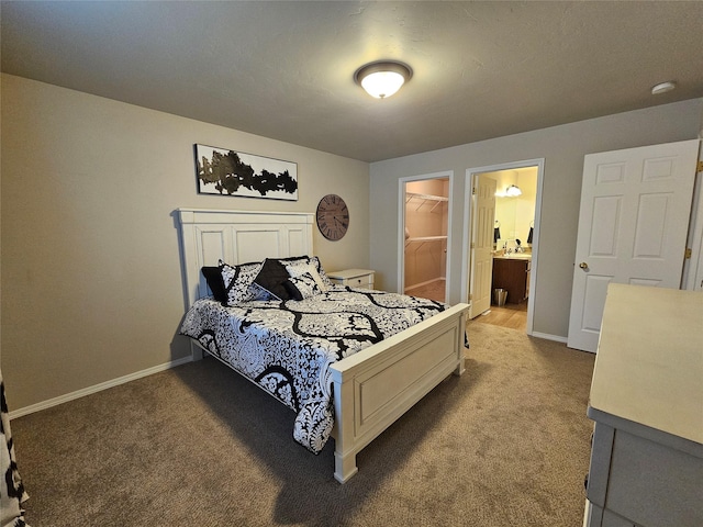 bedroom with light carpet, a walk in closet, and baseboards