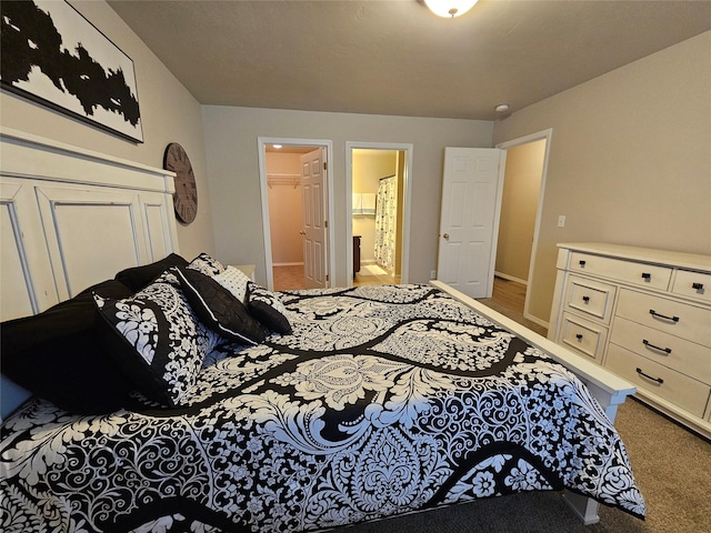 bedroom featuring ensuite bath and carpet floors