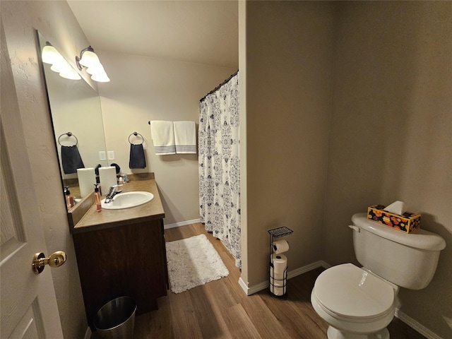 full bathroom featuring baseboards, toilet, wood finished floors, and vanity