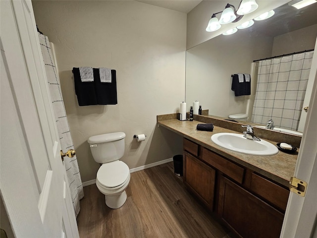 full bathroom featuring baseboards, toilet, wood finished floors, and vanity