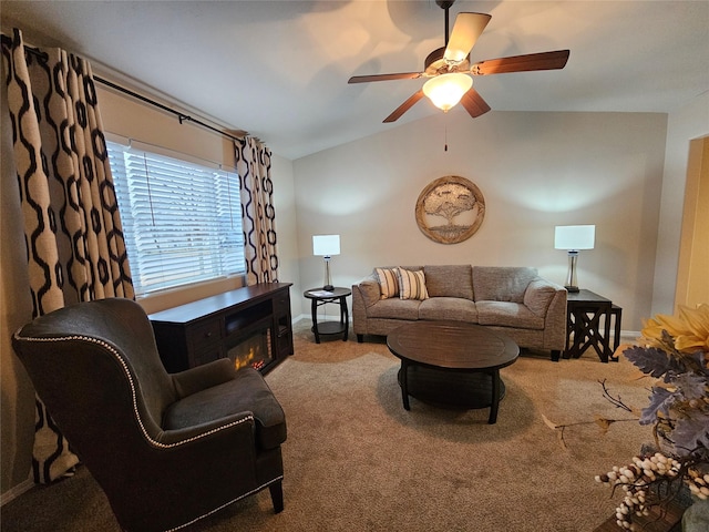 carpeted living room featuring baseboards, lofted ceiling, a glass covered fireplace, and a ceiling fan