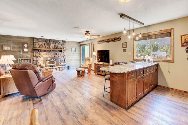 7415 Wildcat St, Helena, MT 59602 - kitchen with light wood-style flooring, open floor plan, a kitchen bar, a peninsula, and brown cabinets