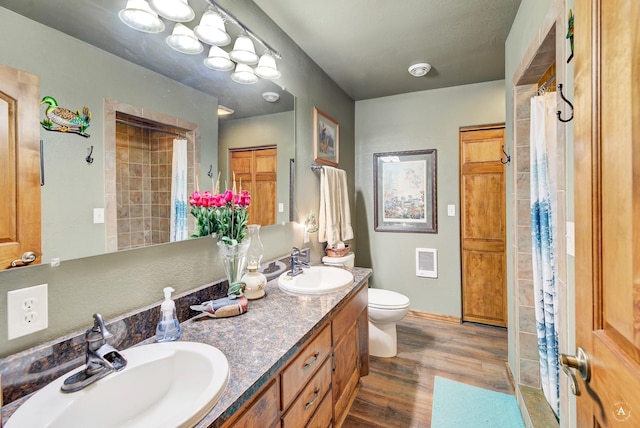 7415 Wildcat St, Helena, MT 59602 - full bathroom with wood finished floors, toilet, double vanity, heating unit, and a shower with shower curtain