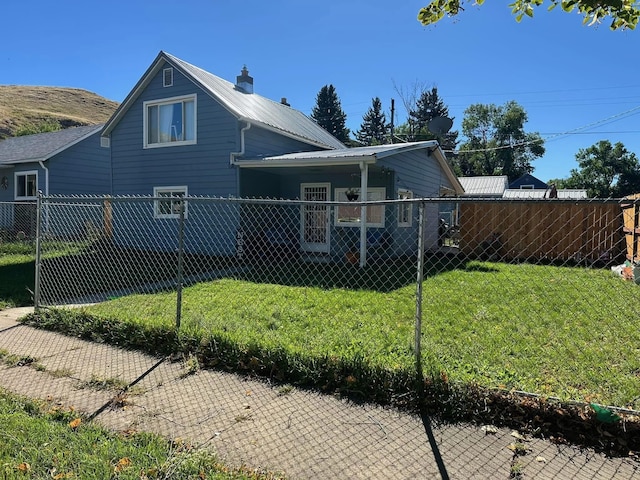 view of side of home with a yard, fence private yard, and metal roof