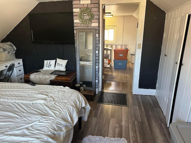 bedroom with lofted ceiling and wood finished floors